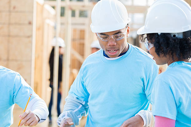 istock Young male volunteer foreman discusses building plans 524543870