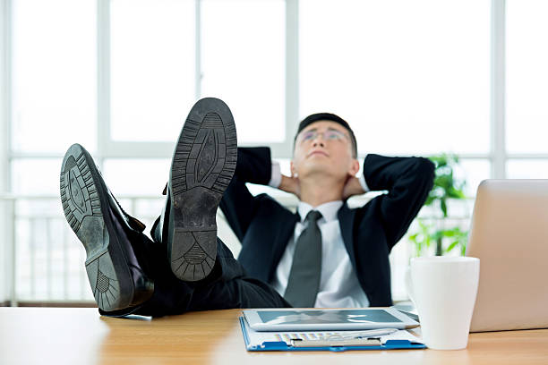 istock Businessman with feet up on desk 524545732