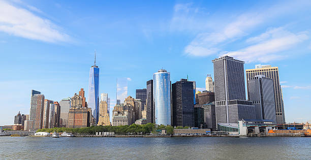 Panorama view of Manhattan Panorama view of Manhattan, New York City with blue sky and slightly cloud. Battery park on the edge of the shore which surround by many tall building in business area. harlem park stock pictures, royalty-free photos & images