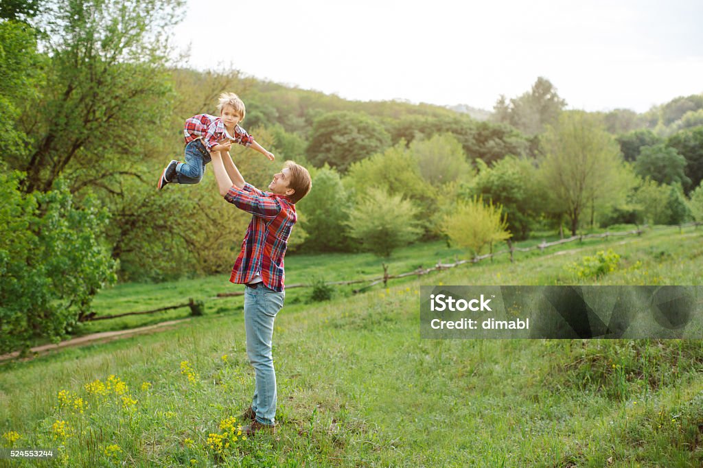 Poco lindo niño jugando al aire libre con el uso de un papá - Foto de stock de 18-23 meses libre de derechos