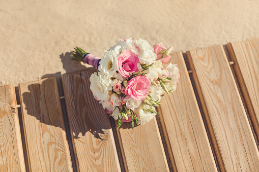 Bride's Pink and White Bouquet Laying on Pier. Wedding in Tropical Country Idea