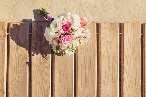 Bride's Pink and White Bouquet Laying on Pier. Wedding in Tropical Country Idea