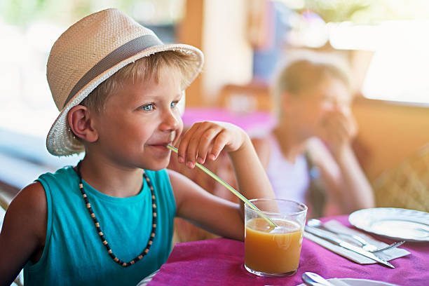 istock Little boy drinking a glass of peach juice 524556140