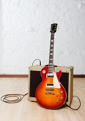 Cape Town, South Africa - May 14, 2009: Gibson Les Paul Standard electric guitar leaning on a Peavey Classic 30 guitar amplifier. This guitar, painted in a colour scheme called cherry sunburst, was manufactured by Gibson USA in 1992. The amplifier is a retro-styled all-tube model called a Peavey Classic 30.