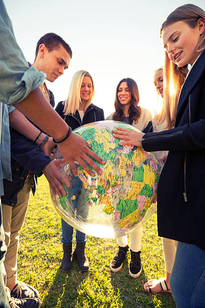 istock Group of young people holding a world globe 524576185