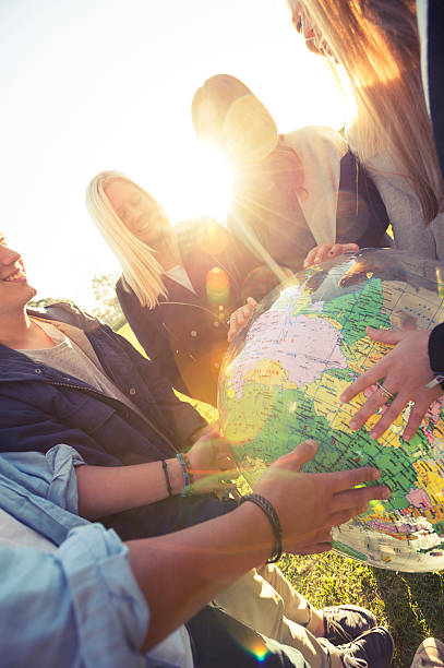 istock Group of young people holding a world globe 524576187