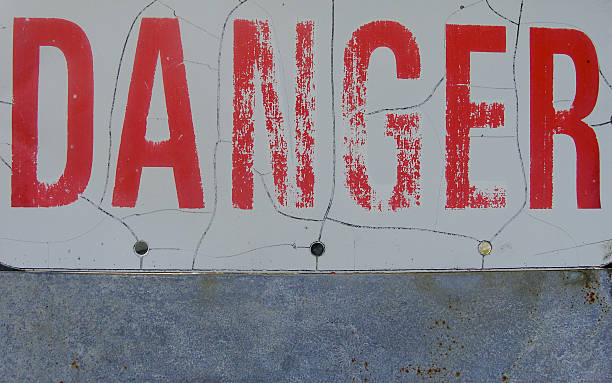 istock fading red danger sign above metal plate 524576825