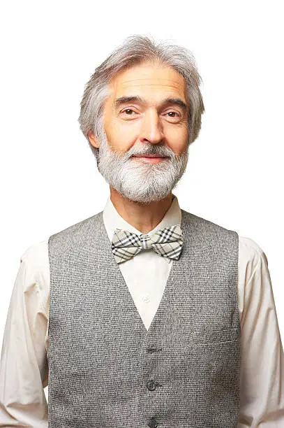 Portrait of an aged caucasian man with a grey beard and bowtie isolated on white background