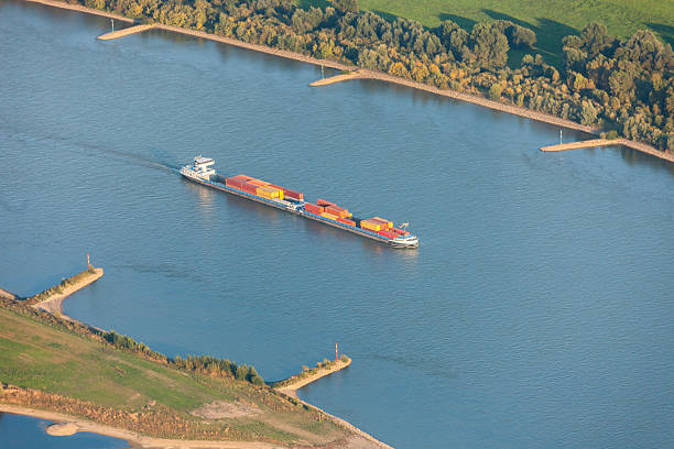 Rhine River with Container Ship in the Lower Rhine Region Rhine River with Container Ship in the Lower Rhine Region of Germany - Rheinberg, North Rhine-Westfalia, Germany, Europe rheinberg illumination stock pictures, royalty-free photos & images