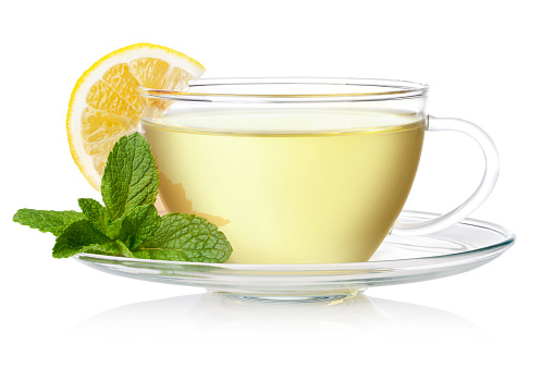 Cup of green tea with mint and lemon on a white background