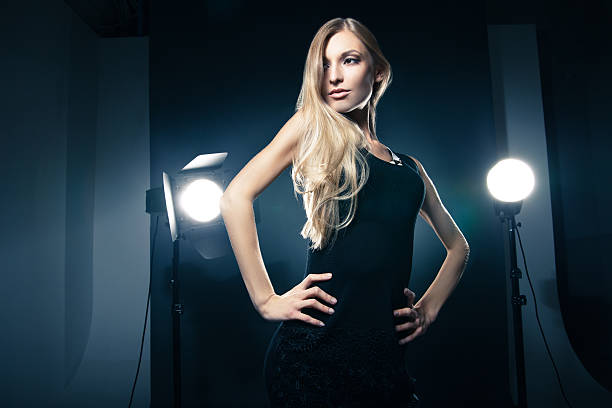 istock Beautiful woman posing at studio in light flashes 524619343