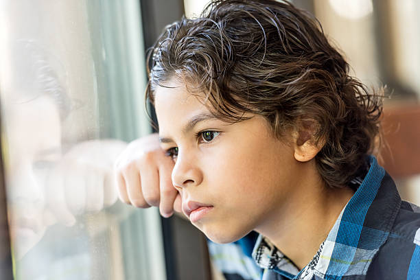 Hispanic Little boy Pensive hispanic little boy looking through a window critical thinking kids stock pictures, royalty-free photos & images