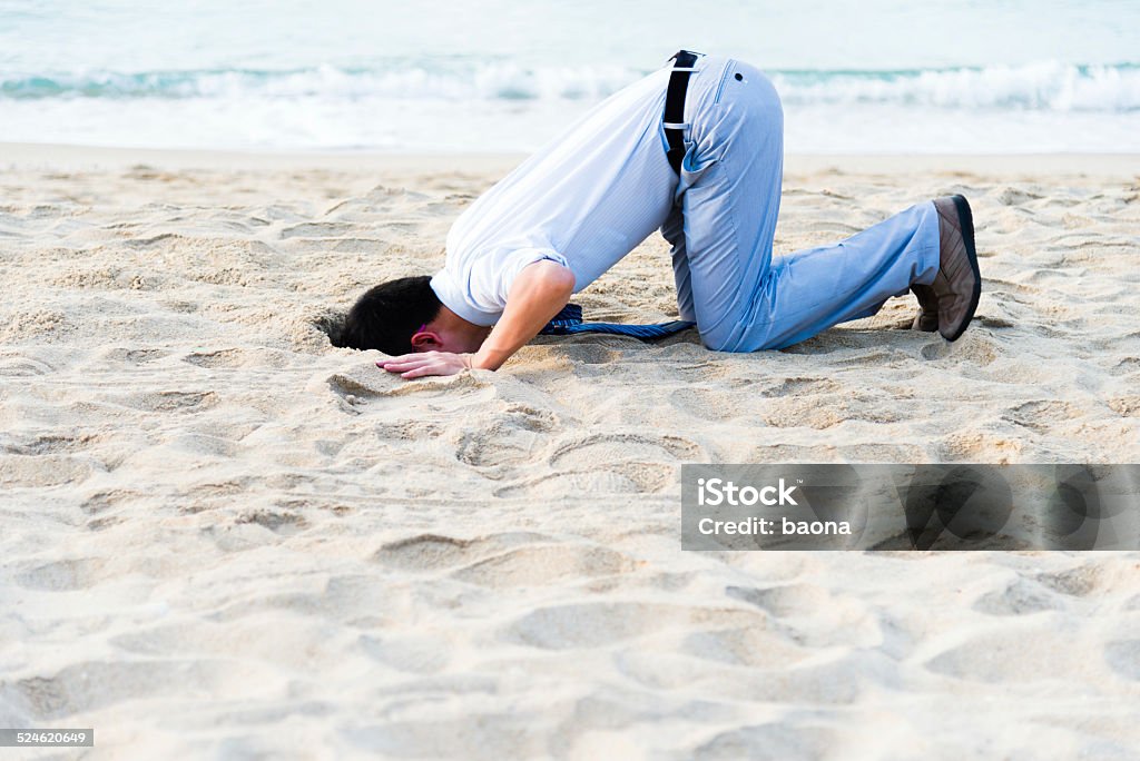 head in sand A businessman hiding head in sand. Buried Stock Photo