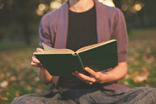 istock Woman reading in park at sunset 524623073