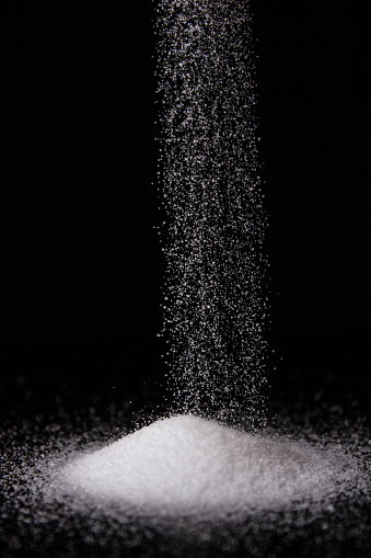 A pile of salt with more salt falling down.