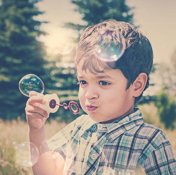 istock Happy little boy blowing bubbles outdoors 524649859