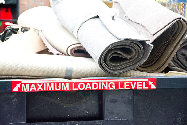 Overloaded dumpster This dumpster is filled to overflowing with old carpets. overflowing dumpster stock pictures, royalty-free photos & images
