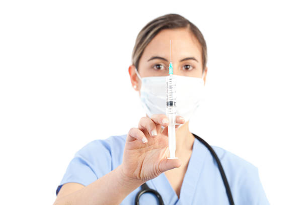 jovem médico feminino segurando uma seringa - syringe medical injection surgical needle surgical mask - fotografias e filmes do acervo