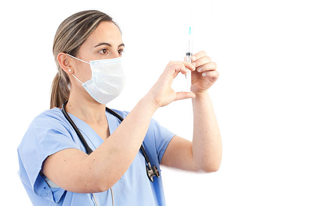 joven mujer médico sostiene la jeringa - syringe medical injection surgical needle surgical mask fotografías e imágenes de stock