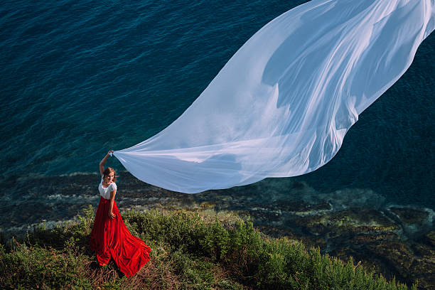 istock Beautiful Girl With White fabric on sea background 524650745