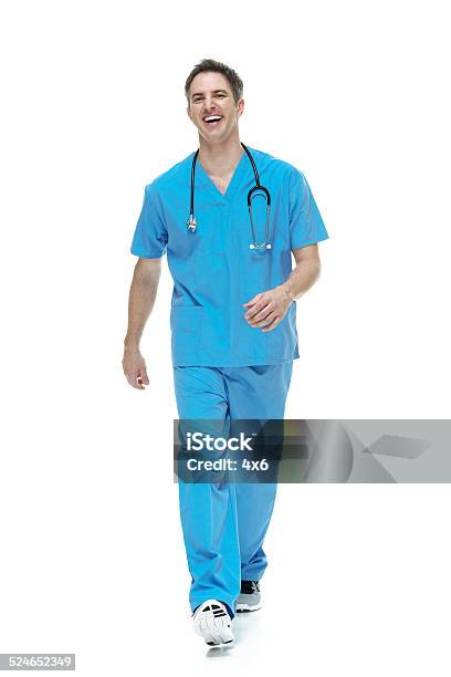 Cheerful Doctor Walking Stock Photo - Download Image Now - Doctor, Walking, White Background