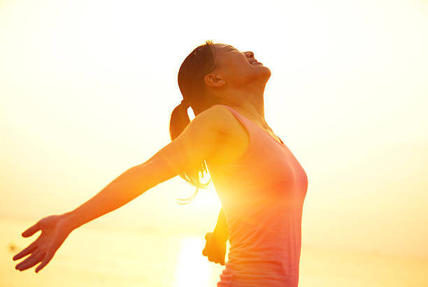istock cheering woman open arms to sunrise at seaside 524652925