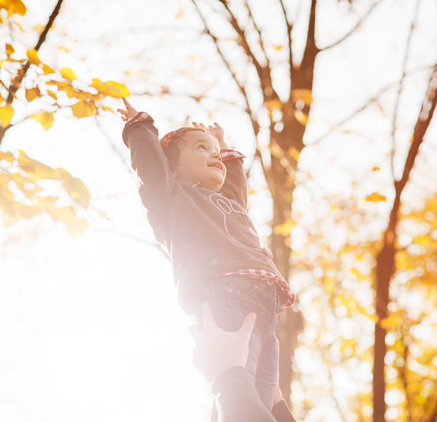 istock Little girl with hands up touching sky 524688091