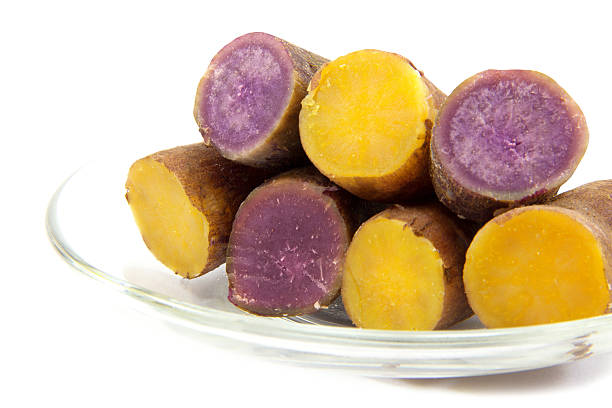 Boiled purple and yellow yams boiled in transparent plate on white backgroundBoiled purple and yellow yams in transparent plate on white background