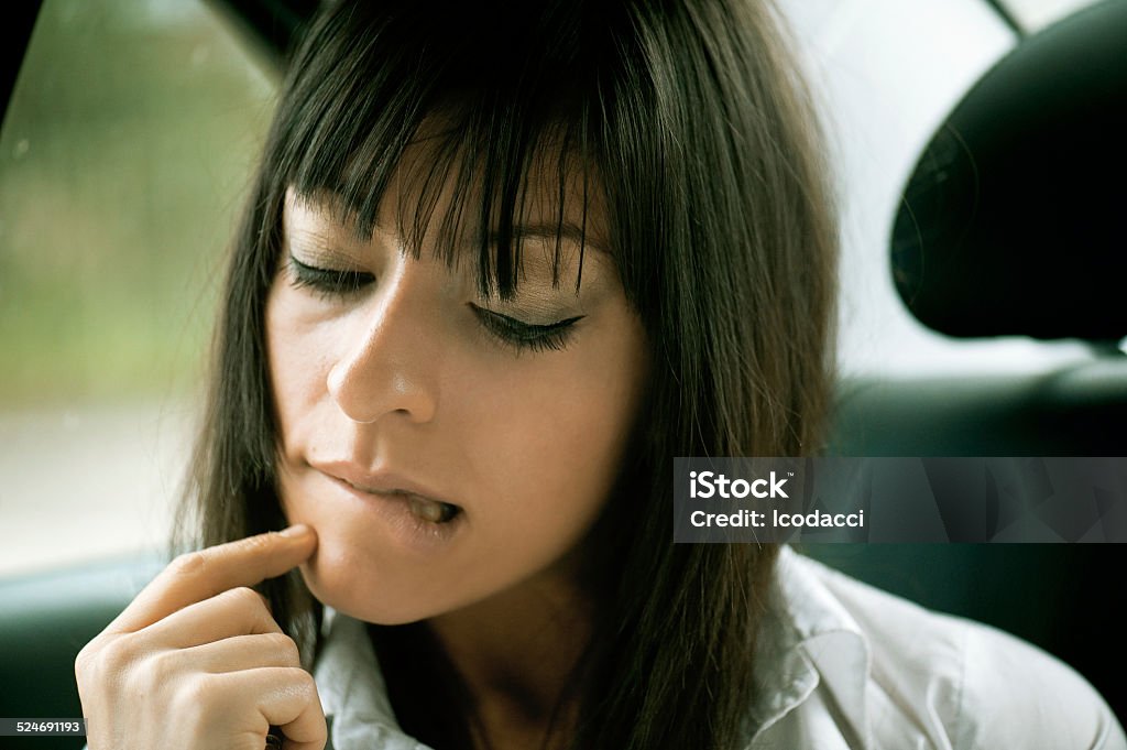 Young woman works from the backseat of a luxury car Sexy business woman in the traffic thinking at her next article to write. Adult Stock Photo