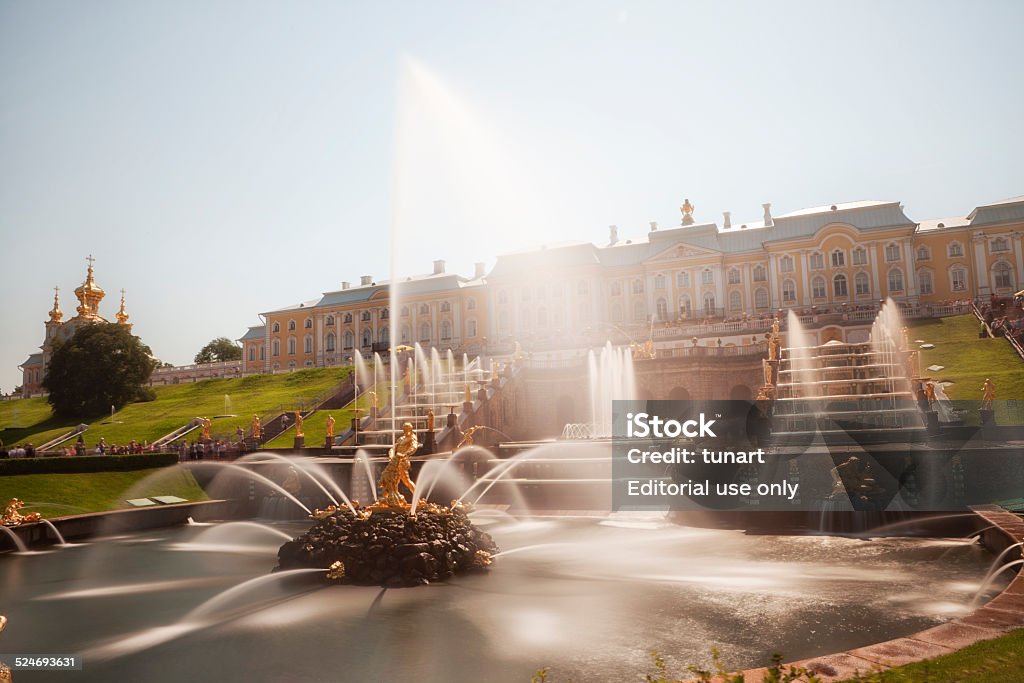 Garden Cascade of Peterhof Palace, Saint Petersburg, Russia Saint Petersburg, Russia - July 29, 2012: Tourists visiting the Peterhof Palace gardens (built in 18th century) which are a series of palaces and gardens, laid out on the orders of Peter the Great. The palace-ensemble along with the city centre is recognised as a UNESCO World Heritage Site. Upon the bluff's face below the Palace is the Grand Cascade (Bolshoi Kaskad). This and the Grand Palace are the centrepiece of the entire complex. Petergof Stock Photo