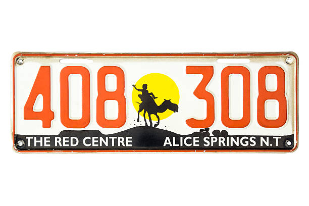 Sydney, Australia - November 22, 2014: An expired Alice Springs, Northern Territory vehicle license plate, bearing the digits 408308 and slogan 'The Red Centre'. Depicted is also a silhouette of a person riding on a camel at sunset.
