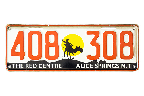 Sydney, Australia - November 22, 2014: An expired Alice Springs, Northern Territory vehicle license plate, bearing the digits 408308 and slogan 'The Red Centre'. Depicted is also a silhouette of a person riding on a camel at sunset.