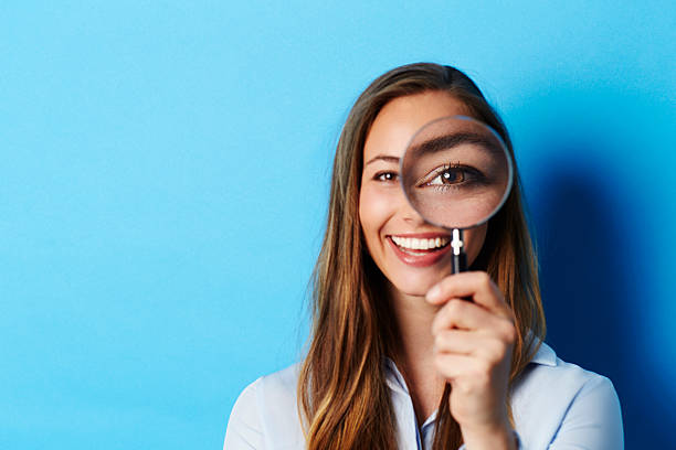 istock Beautiful brunette in focus with magnifying glass 524699984