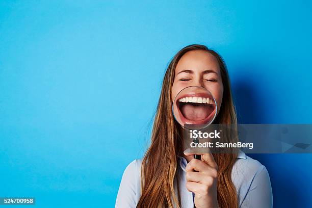 Beautiful Woman Laughing Through Magnifying Glass Stock Photo - Download Image Now - Laughing, Humor, One Woman Only