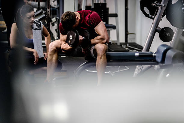 istock Personal trainer assisting athletic client in weightlifting gym 524703320
