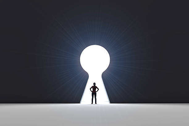 istock Figure in front of a bright keyhole opening 524704232