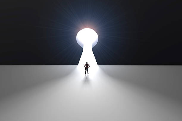 istock Figure in front of a bright keyhole opening 524704330