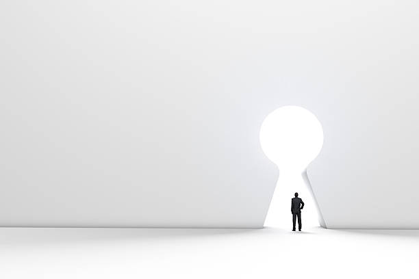 istock Figure in front of a bright keyhole opening 524704498