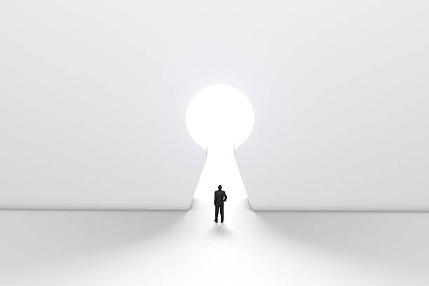 istock Figure in front of a bright keyhole opening 524704516