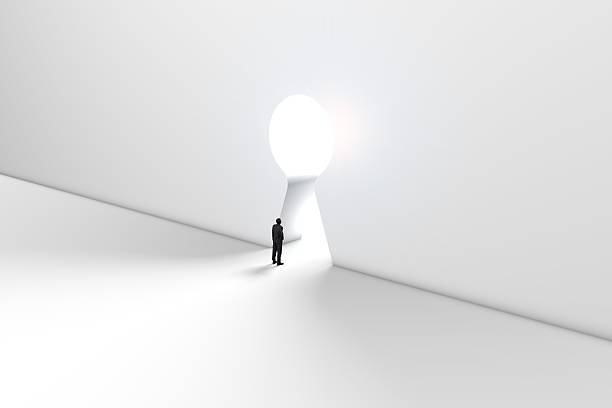 istock Figure in front of a bright keyhole opening 524704536