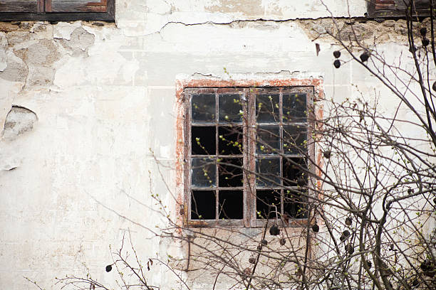 istock Window with shattered glass, ruined stone house. 524704994