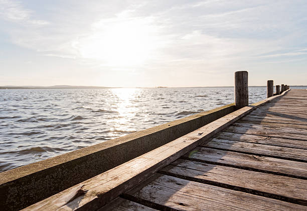istock Jetty, lake and blue sky back lit as background 524705690