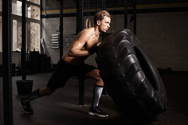istock Man pushing tire in gym 524707566
