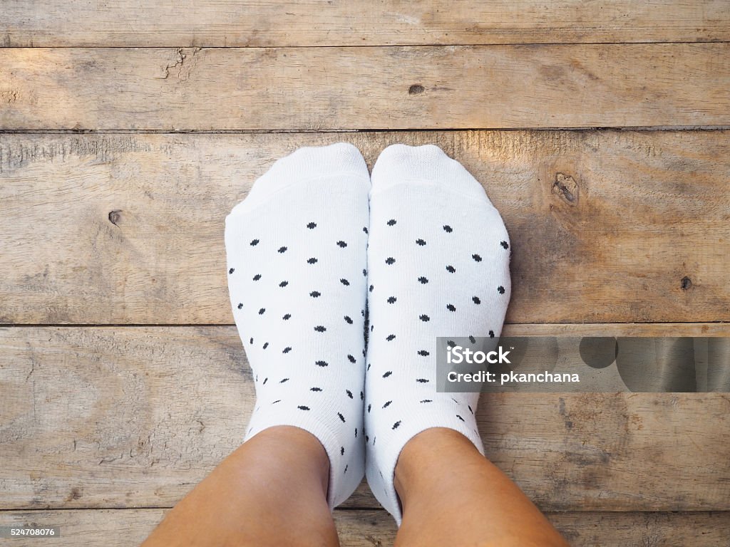 feet wearing white polka dot socks Selfie feet wearing white polka dot socks on wooden floor background Polka Dot Stock Photo