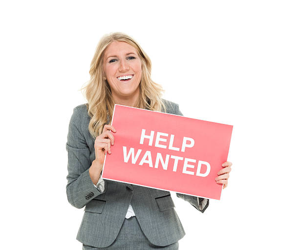 istock Cheerful businesswoman holding help wanted sign 524708514
