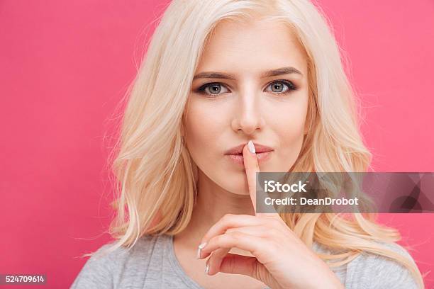 Pretty Woman Showing Finger Over Lips Stock Photo - Download Image Now - Adult, Advertisement, Backgrounds