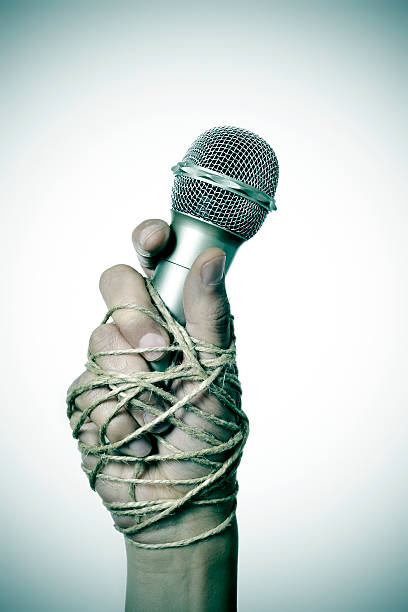 istock man with a microphone tied with rope 524712726