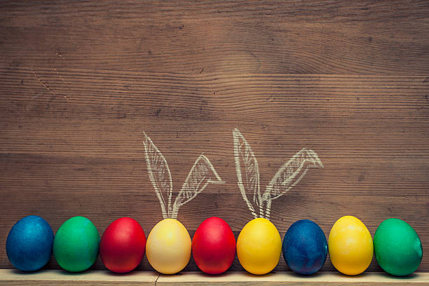 uova di pasqua con orecchie di coniglio su uno sfondo di legno texture - wood eggs easter easter egg foto e immagini stock