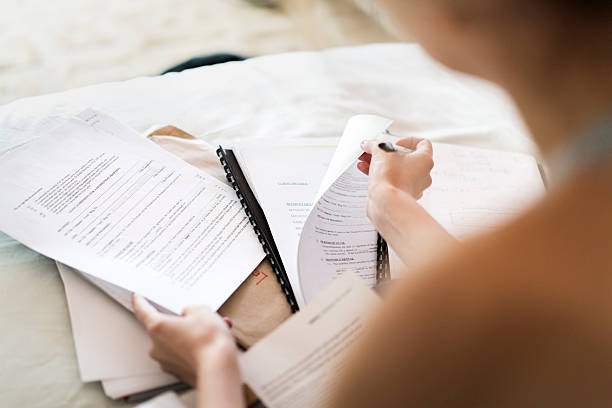 istock Cropped image of woman with paperwork on bed 524715628