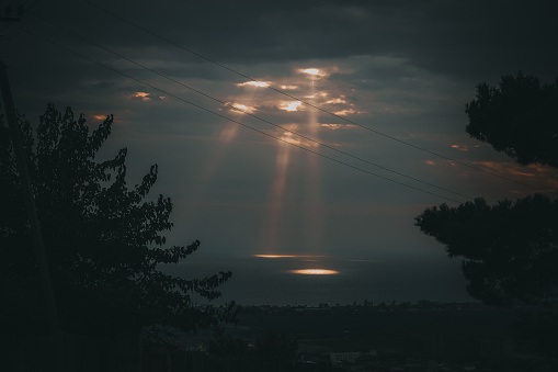 The rays of the sun in the morning over the city and the sea.